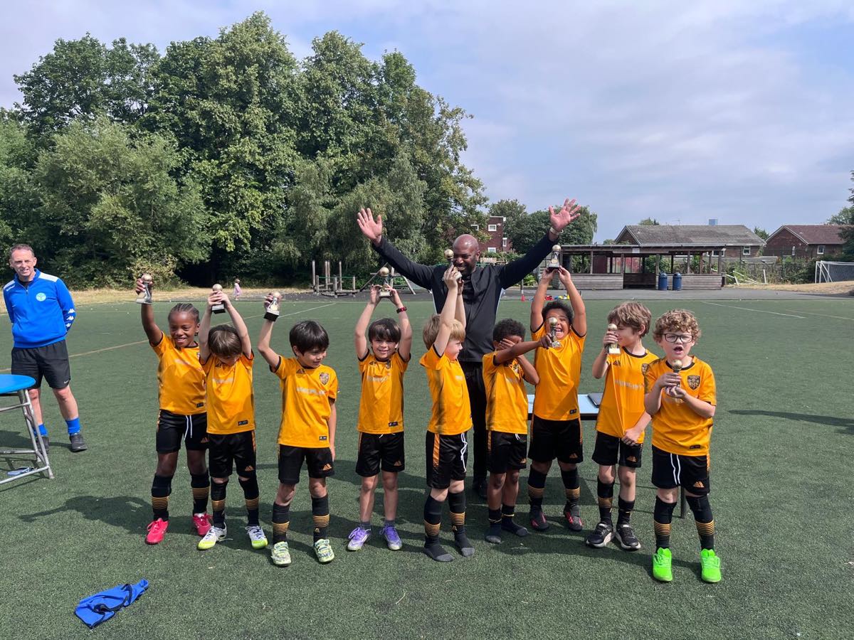Chorlton Rovers players celebrating with their trophies and coach at Hough End
